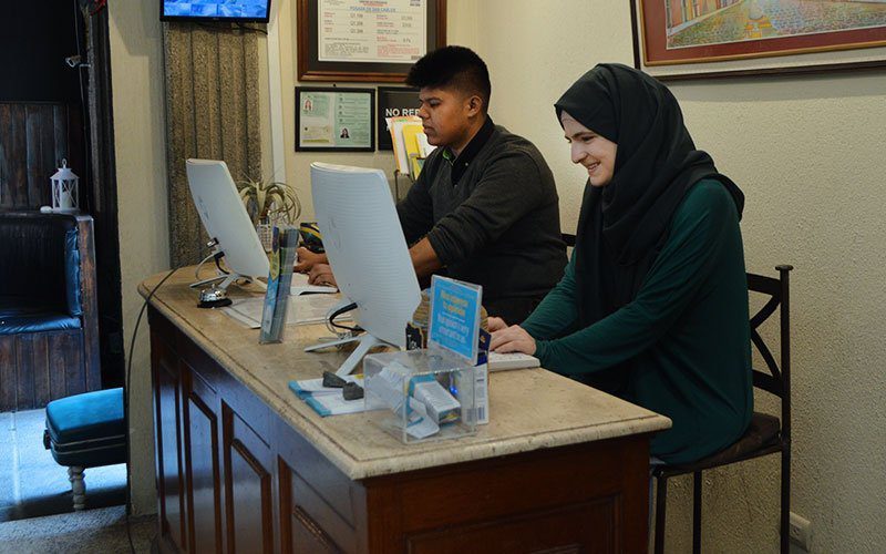 International interns managing front-desk operations, showcasing hands-on hospitality and tourism experience abroad.