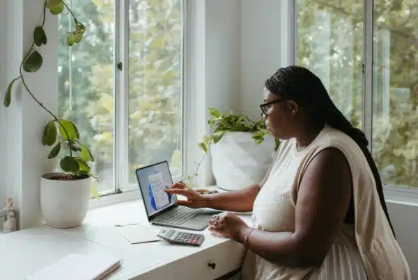 Remote professional reviewing data on a laptop by a bright window, showcasing the location-independent nature of virtual internships.